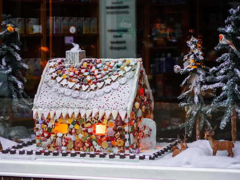 A lighted gingerbread house in the window of a store