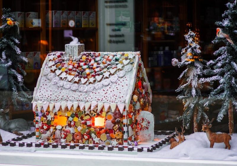 A lighted gingerbread house in the window of a store